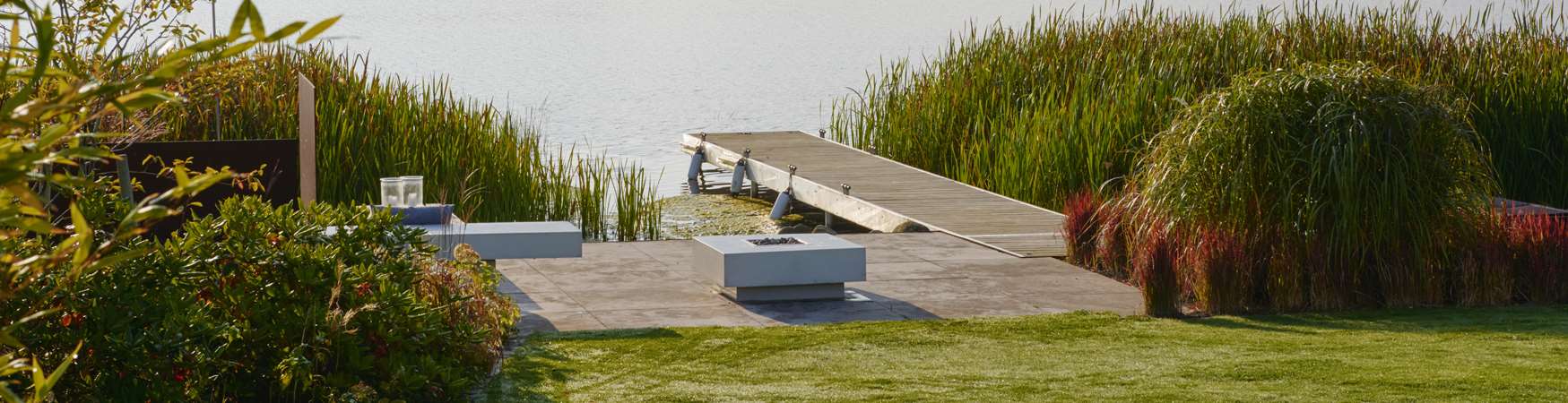Træterrasse med Haddeland Lounge og gasbål ved sø designet af havearkitekt Tor Haddeland